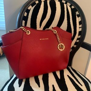 Michael Kors red purse with gold chain straps.